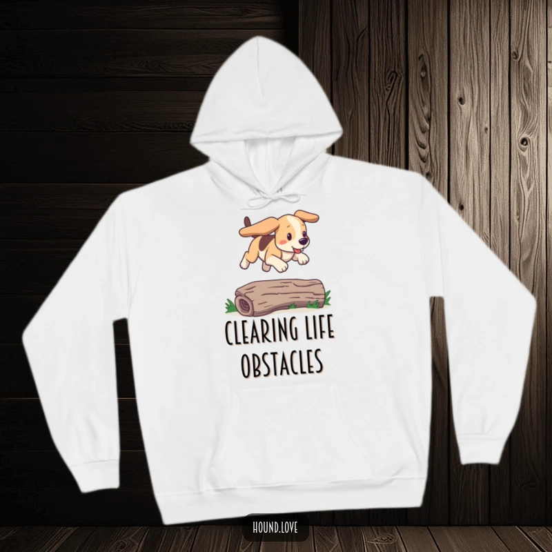 Funny hound hoodie featuring a dog joyfully bounding over a log with floppy ears. Cozy, humorous comfort for dog lovers.